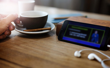 Hand of businessman holding coffee cup while working and use smart phone meeting or seminar online on wooden table