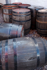 A bunch of old whisky barrels left outside to weather in the elements.