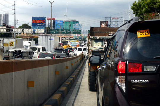Cars, motorcycles and other vehicles travel along a traffic congested road