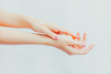 Naklejka premium Woman with french manicure applies cream to her hands