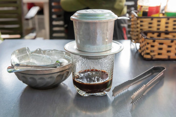 Coffee in a Vietnamese coffee maker and a bowl of ice