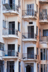 Architectural background with destroyed residential buildings with balconies and broken shutters