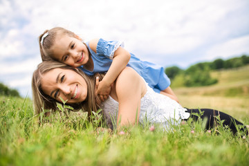 Happiness mother with her daughter lay on the ground