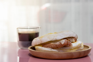 Ciabatta bread with arabiki sausage and cheese, Black coffee on wooden table.