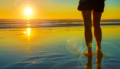 woman leg on the beach- walking on the beach in sunset time