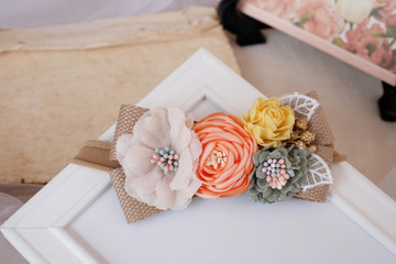 Handmade flower made out of fabric cloth textile in beautiful soft pastel colors placed on white photo frame that can be used as hair accessory, decoration, and embellishment