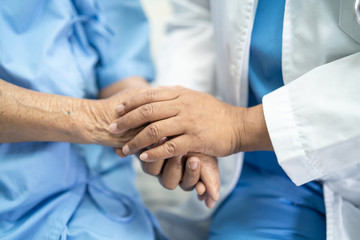 Doctor holding touching hands Asian senior or elderly old lady woman patient with love, care, helping, encourage and empathy at nursing hospital ward, healthy strong medical concept