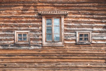 Fototapeta na wymiar Wall of an old farm building. Natural wooden texture, rural house for agritourism, different windows, country house