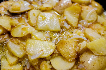 Typical Spanish dish made from potatoes and garlic, fried in a pan with olive oil, seen from above