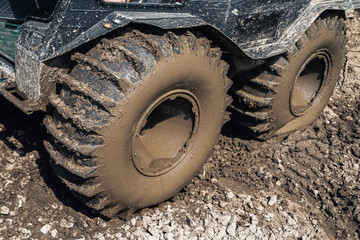 Fototapeta na wymiar Close-up dirty wheels of All-terrain vehicle, off-road. Off-road vehicle for extreme driving, outdoor countryside challenge. Adventure concept
