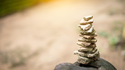 The stones are stacked in the forest with a blurred background.