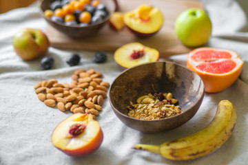 
Making a vegan smoothie bowl with peach, banana, chia, granola and almonds in a coconut bowl. Vegan breakfast.  Almond heart