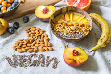 Balinese smoothie bowl with banana, chia seeds, peach, plum, muesli and coconut. Vegan lettering and heart made from almonds and chia seeds. I love vegan lettering
