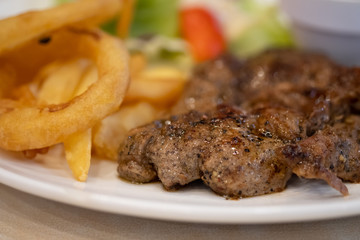 Pork steak with black pepper sauce, salad and French fries