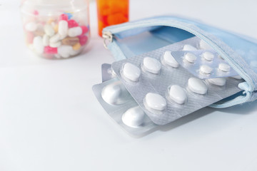 close up of colorful pills and blister pack on white background 