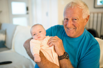 Grandfather on the sofa with baby at home