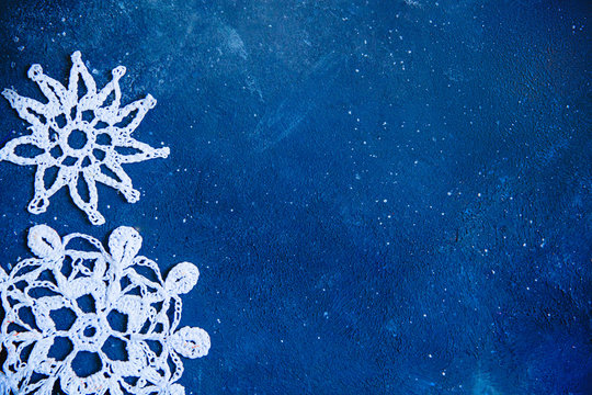 Dark blue frayed texture with white knitted snowflakes . Christmas background