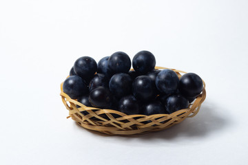 Plum in a wicker basket. Photo on a white background. Summer harvest