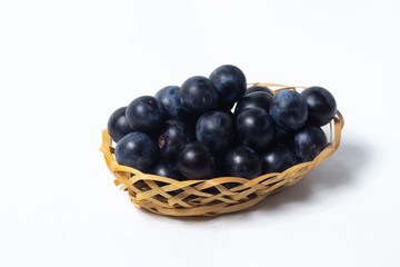 Plum in a wicker basket. Photo on a white background. Summer harvest