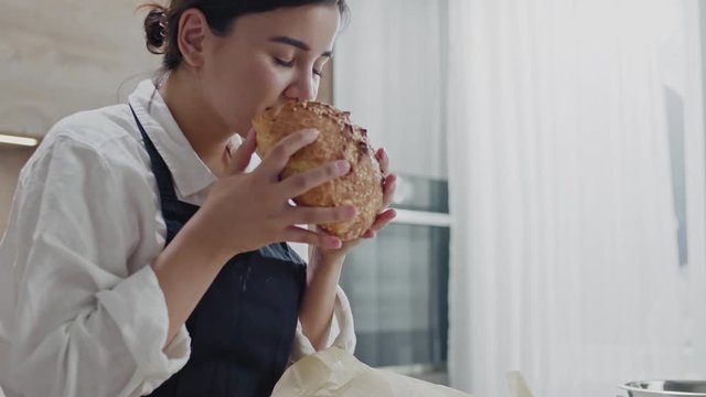Beautiful Baker Smells Freshly Baked Bread.