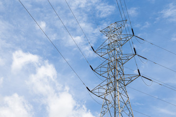 High voltage pole with blue sky and cloud in background.