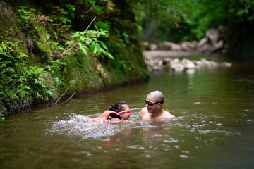 川で遊ぶ父と娘
