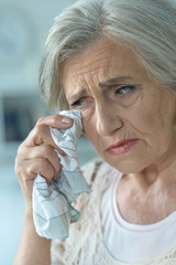 Close-up portrait of stressed senior woman crying