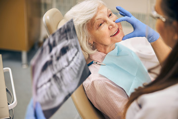 Happy lady making regular check up in modern clinic