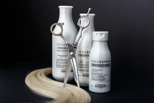 L'oreal Professionnel Paris Serie Expert Silver Hair Professional Products.Loreal Shampoo Cream Mask For Grey White Hair. Professional Hairdresser Scissors And Lock Of Blonde Hair On Black Background