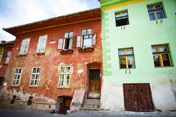 Fototapeta na wymiar Beautiful colorful street in Sighisoara in typical traditional style. Sighisoara is the place Dracula is born.