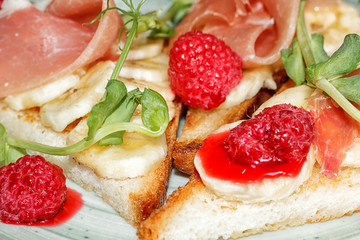 toast with banana, raspberries, pea sprouts and meat