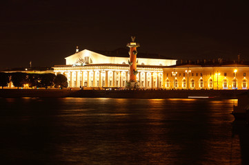 Fototapeta na wymiar Landmarks in the city of St. Petersburg in Russia, the embankment of the Neva River with Rastral columns on the other side at night with illumination