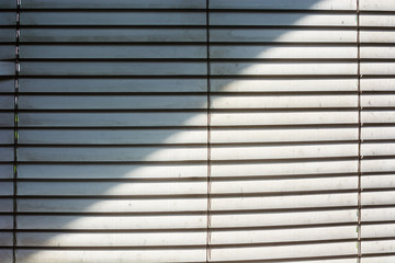 dusty blinds on white windows with sun shade

