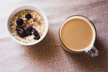 a glass cup of coffee with and oatmeal with strawberry jam
