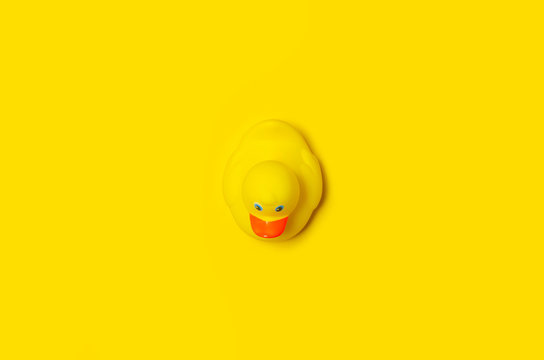 Yellow rubber duck on yellow background isolation, top view