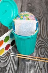 Globe with medical mask. Lies in a trash can. Nearby watercolors and brushes. Academic year during the epidemic.