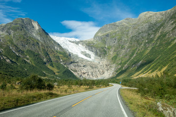 Fototapeta premium Norwegian mountain road with Josteldalsbreen glacier in the background