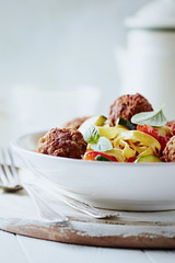 Pappardelle Pasta with Meatballs and fresh Basil on bright background. Close up.	
