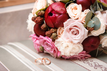 flowers , bride bouquet of maroon and pink peonies, white roses, 2 gold wedding rings, wedding decor,