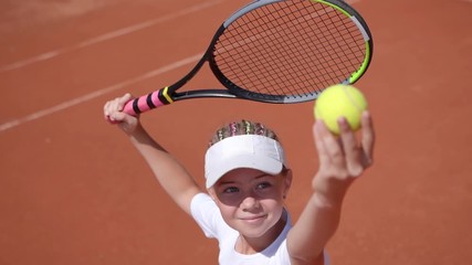 A young tennis player serves in a tennis game. Slow motion.