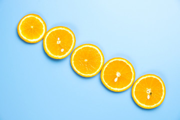 Flat lay view of orange slices on blue backround.