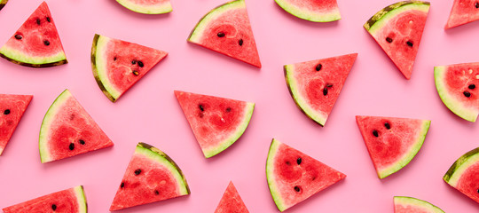 Watermelon colorful pattern on pink background. Fresh red watermelon slices closeup, wallpaper, top view. Creative summer concept, fashionable trendy flat lay