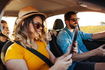 Family road trip. Latin family traveling locally by car. Using map on tablet for navigation