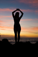 silhouette of girl at the beach at sunset