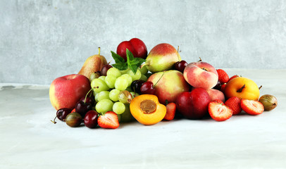Fresh summer fruits with apple, grapes, berries, plums and healthy apricot.