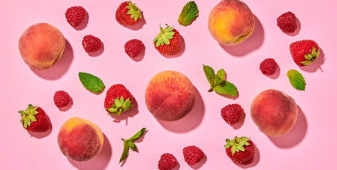 Peach, raspberry, strawberry colorful pattern on pink background. Fresh peach closeup, bilberry wallpaper, top view. Strawberry, mint creative concept, fashion trendy flat lay