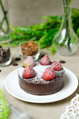 Mousse chocolate cake with strawberry and icing powder sugar. set on cafe table.