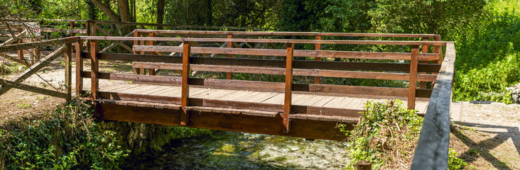 wide shot of wooden footbridge in Posta Fibreno nature reserve of the Italian Lazio region
