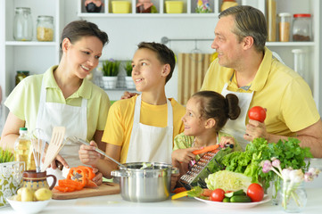 Portrait of cute family cooking together in kitchen