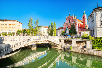 Fototapeta na wymiar Ljubljana City Center during a Sunny Day overlooking the Triple Bridge and Beautiful Franciscan Church